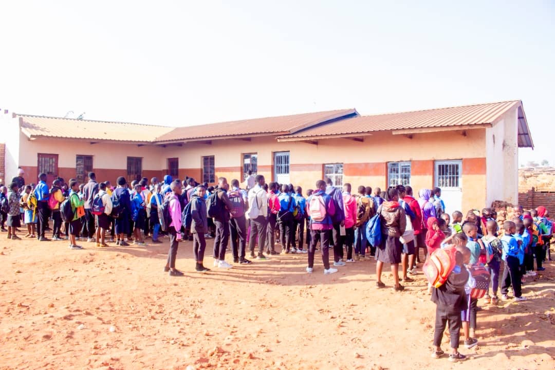 Students with backpacks gathered outside a school building